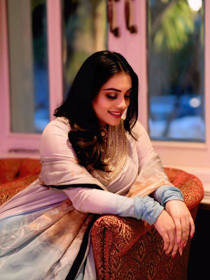 Soft hues, strong vibes. A graceful portrait of a woman in a beautiful pastel-colored suit, her gentle smile capturing a moment of quiet elegance.