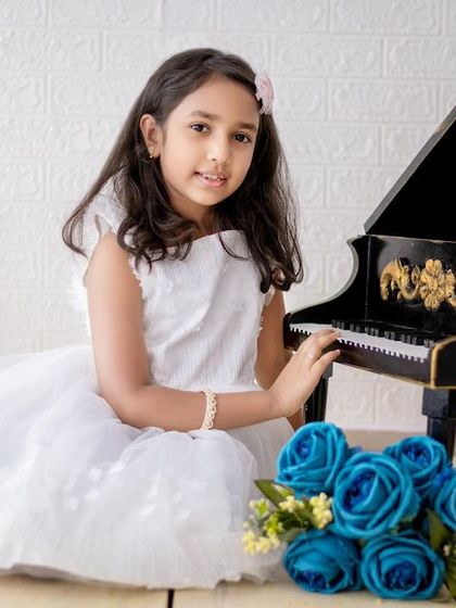An elegant portrait of an older girl at our miniature piano. We adapt our setups and posing for children of all ages.