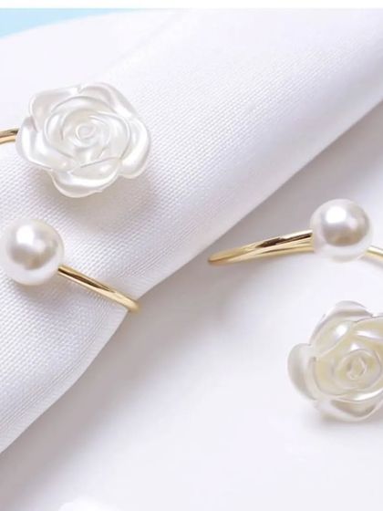 These pearl and rose napkin rings are the perfect accessory for an elegant table setting. The delicate white rose and single pearl create a look of simple sophistication.