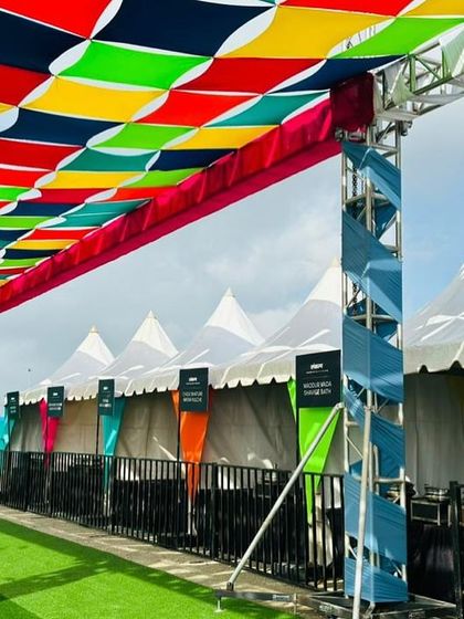 A closer look at the colorful truss structure and tents at the Ola factory event. Our team uses creative design elements to transform large, open spaces into lively and welcoming event zones.