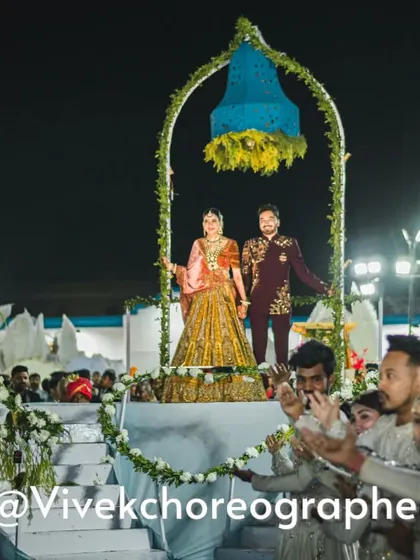 A close-up of the couple on a moving stage during their varmala. This custom prop, decorated with a floral bell, allows for a dynamic and cinematic entry.