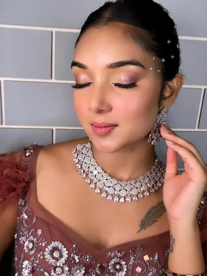 A soft and romantic reception look created by a student. The subtle smokey eye and glowing skin are perfect for an evening event, showcasing their versatility.