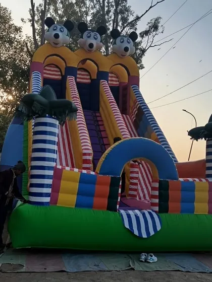 This is our 3-line Mickey Mouse bouncy slide. The striped palm trees and colorful base make it a very attractive option for any party.
