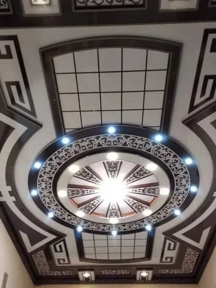 A highly decorative ceiling with intricate black and white patterns. The design uses Greek key motifs and gridded panels to create a bold, classic, and unforgettable look.