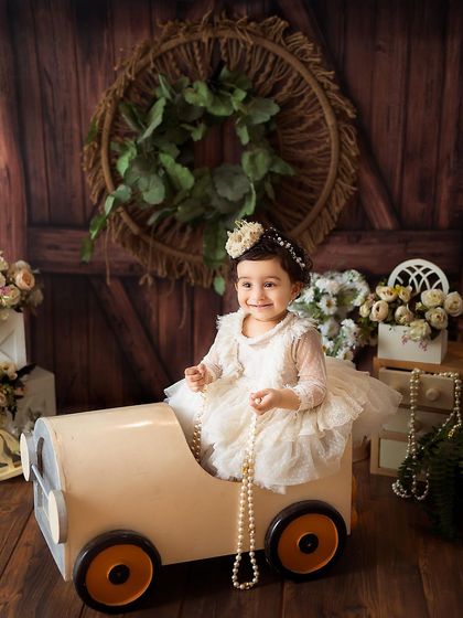 A beautiful portrait in a vintage-style toy car, holding a string of pearls. We use a variety of props to add a touch of elegance and fun to the session.