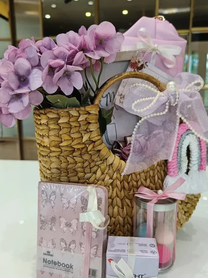 Another angle of our popular pink-themed self-care hamper, showing the arrangement of the notebook, beauty blenders, and other gifts inside the woven basket.
