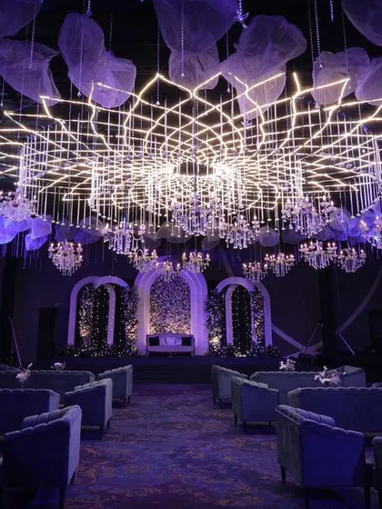 Lighting is not just about illumination; it's about creating an atmosphere. This custom-engineered geometric light installation became the stunning centerpiece of a modern sangeet, bathing the entire venue in a dynamic, warm light.
