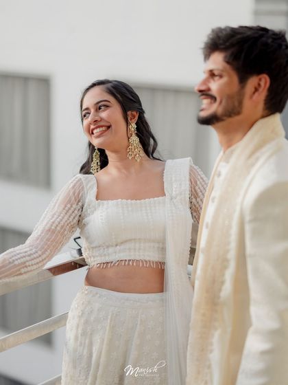 A candid shot of the couple sharing a happy moment on a balcony, their smiles bright and genuine.