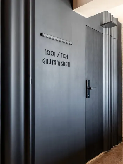A closer look at the custom-designed main door. The matte black finish and sculptural, wave-like forms create a powerful first impression, blending security with high design.