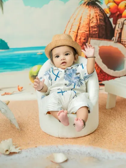 A friendly wave from our tiny beachcomber. I engage with the babies to bring out their personalities, resulting in interactive and lively photos like this one.