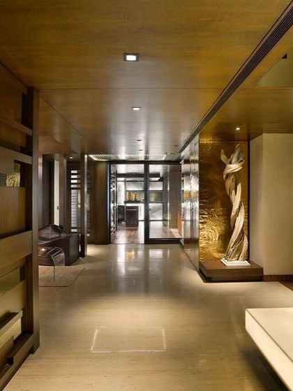 This hallway in a Gurgaon apartment was designed as a gallery-like experience. A sculptural wooden wall, polished marble floors, and carefully placed art create an unfolding sequence that is both dramatic and highly stylized.