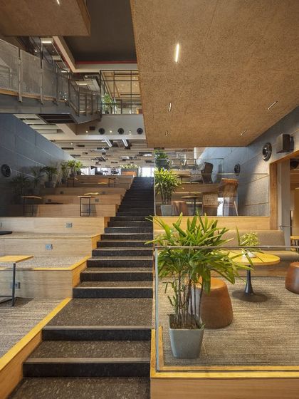 A view from the base of the atrium at Primarc shows how the terraced design creates inviting pockets for pause and conversation. This unconventional layout balances focused work with social interaction, ensuring the space feels deeply human.