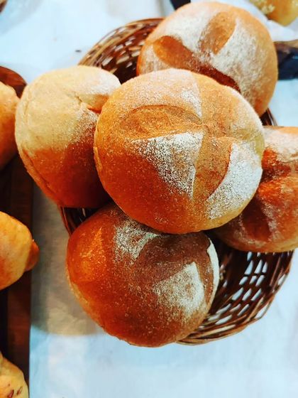 A basket of freshly baked round breads, perfect for soups and sandwiches.