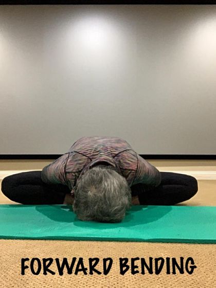 A forward bend on a yoga mat. This type of stretch helps to calm the mind while releasing the hamstrings and lower back.