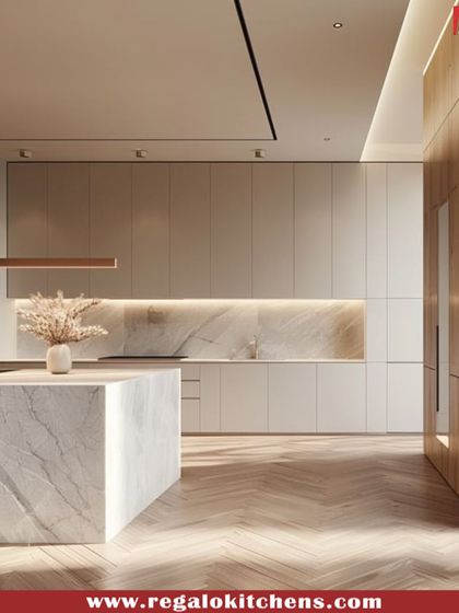 This kitchen design combines a marble island with light wood and beige cabinets, creating a warm and luxurious feel. The herringbone wood floor adds another layer of texture and sophistication.