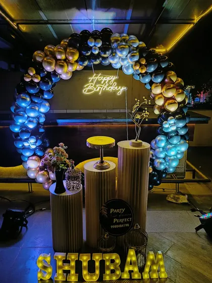 My services are perfect for adult milestone birthdays in any setting, including pubs and lounges. This moody and elegant setup uses a black and gold balloon arch over pedestals, with a custom neon 'Happy Birthday' sign and dramatic lighting to create a sophisticated party atmosphere.