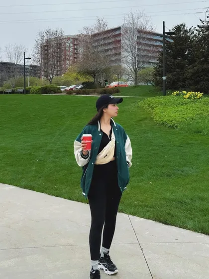 A full-length shot of my casual varsity jacket outfit in a Burlington park.