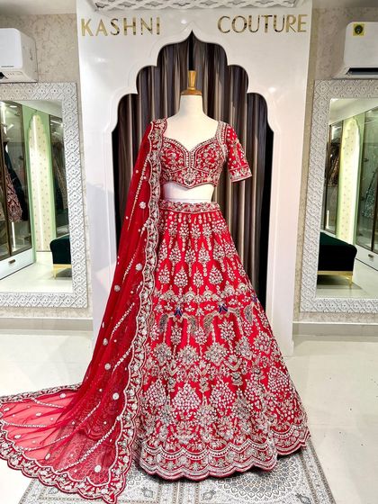 A full view of the royal red lehenga on a mannequin, showcasing its grand silhouette and the beautiful drape of the matching dupatta.