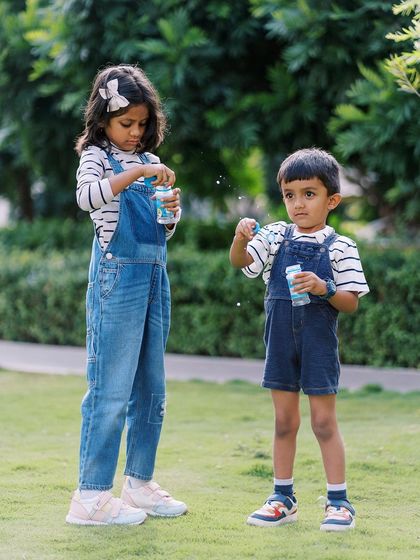 Siblings blowing bubbles together in the park. It's a simple activity, but it creates so much joy and wonderful photo opportunities.
