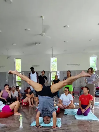 Demonstrating Prasarita Padottanasana in Sirsasana (Wide-Legged Headstand) to the class. This variation challenges balance and increases flexibility.