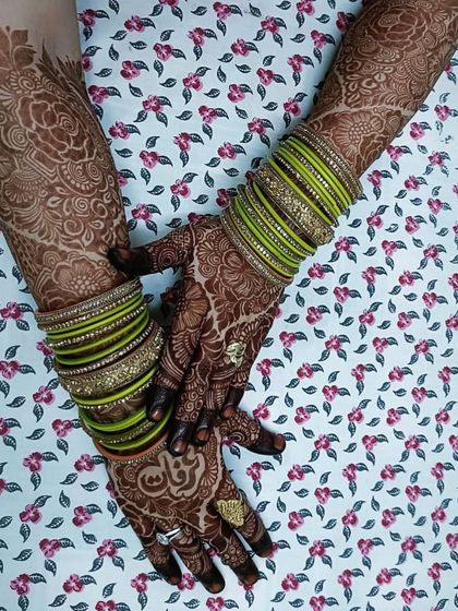 The rich stain of a full bridal mehendi, beautifully accessorized with green bangles.