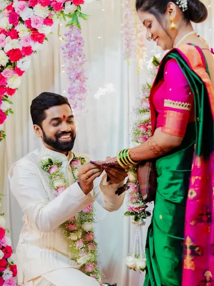 The proposal moment during the engagement ceremony. Amit gets down on one knee to place the ring on Asawari's finger, a gesture full of romance.