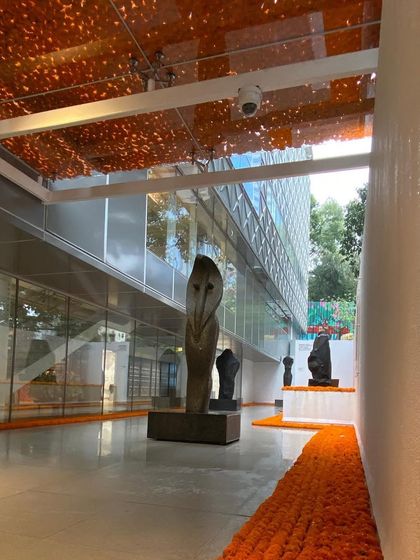 The sculpture court at MAP during a preview event, decorated with marigolds. This shows the space activated by people and cultural traditions, fulfilling its role as a vibrant public venue.
