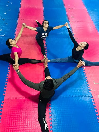 Finding fun and connection in our practice. Students work together to create a formation in Hanumanasana (Split Pose), blending strength with playfulness.