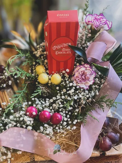 The sweet side of the charcuterie board, with dark chocolate popcorn and candies nestled amongst fresh baby's breath.