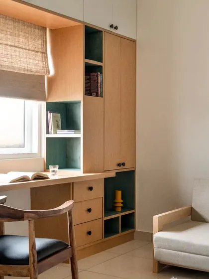 The study nook is designed to be compact yet fully functional, with a mix of open and closed storage integrated around the window.