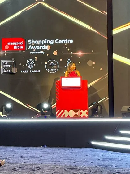A wide shot of the impressive stage for the MAPIC India Shopping Centre Awards. I am experienced in hosting on large, technologically advanced stages.