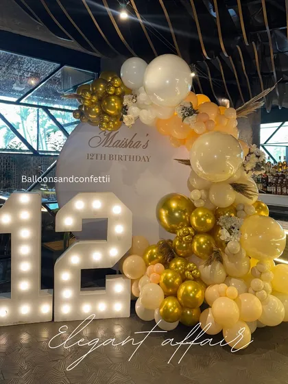 Another angle of the elegant 12th birthday setup, showcasing the beautiful script on the backdrop and the organic flow of the balloon garland.