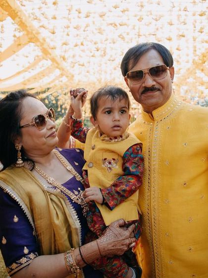 A precious moment with the grandparents. Our little client looks bright and happy in his yellow Bundi set, perfectly dressed for a family wedding's Haldi function.
