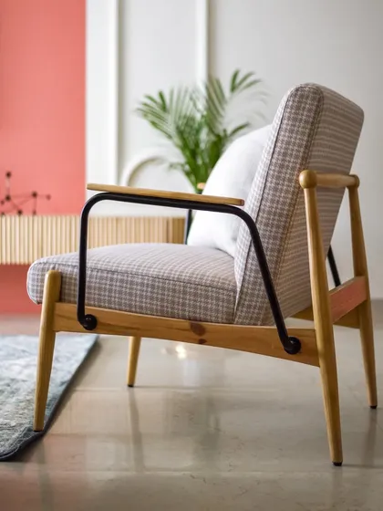 This thoughtfully curated armchair, with its mix of wood, metal, and patterned fabric, adds a touch of personality to the living room.