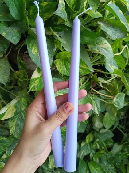 A pair of light lavender taper candles.