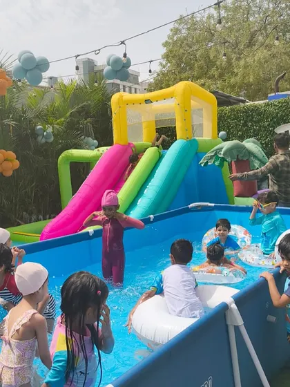 A group of kids enjoying the inflatable water slide, one of the main attractions of our pool parties.