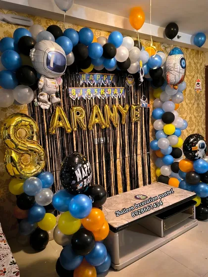 An out-of-this-world Universe theme for an 8th birthday. The balloon arch features astronaut and rocket ship foil balloons, creating a space adventure for the birthday boy.