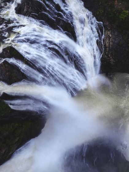 A close-up drone shot of the mighty Shivanasamudra falls, capturing the texture and power of the water as it plunges down the Kaveri river.