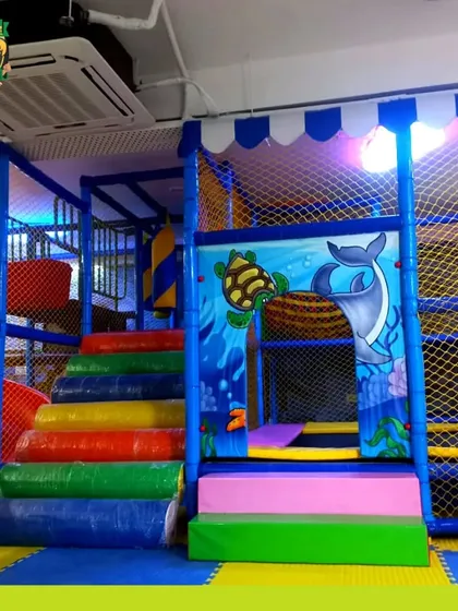 A clear shot of the padded rainbow stairs leading up into the multi-level play maze, designed to be safe and inviting for young climbers.