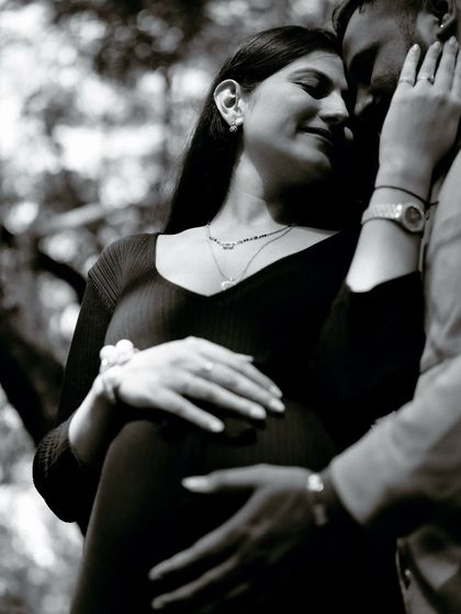 An intimate black and white close-up of the couple embracing in the woods. The soft focus and their gentle expressions make this a very tender and emotional portrait.