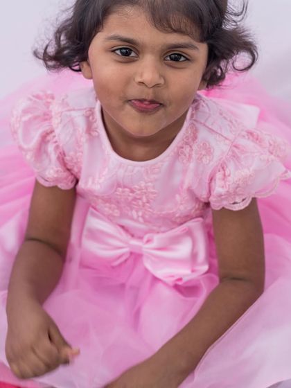 A sweet portrait in a perfect pink princess dress. The puff sleeves, embroidered bodice, and full tulle skirt come together to create a look straight out of a fairy tale.