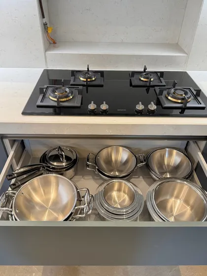 A drawer next to the stove, organized with steel pots and bowls. This placement follows our principle of storing items at their point of use for maximum convenience.