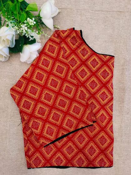 This red cotton boatneck blouse features a geometric diamond print.