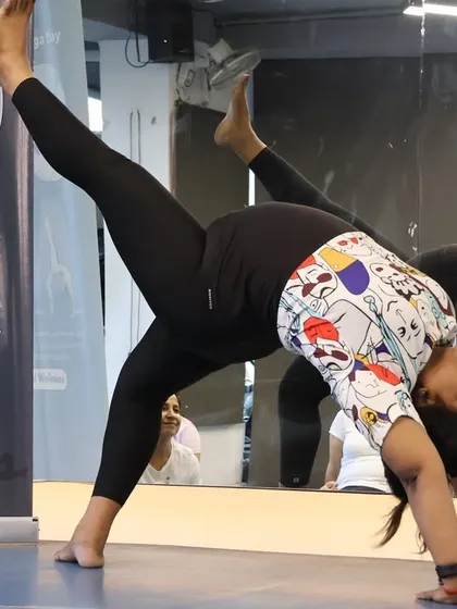 A member showcases her strength and flexibility with a challenging standing split pose.