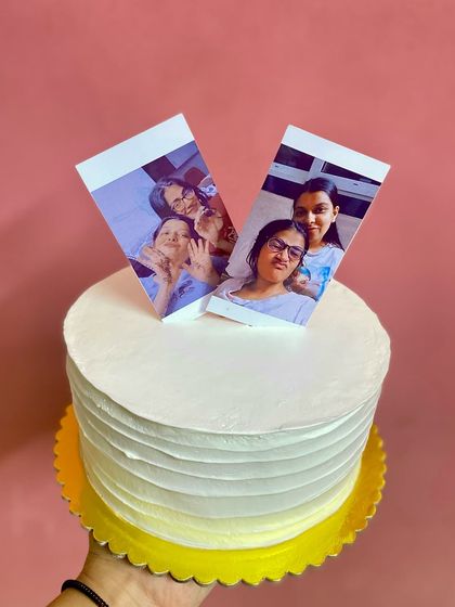 A hand-held view of the minimalist photo cake, a chic and personal way to celebrate.