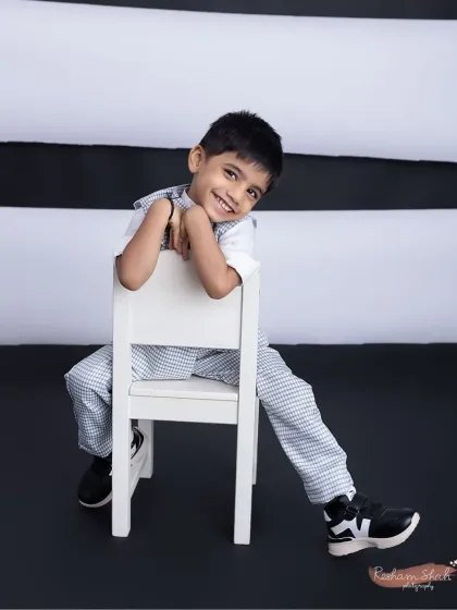 Leaning back with a cool, relaxed smile. This shot perfectly captures his charming and easy-going personality.