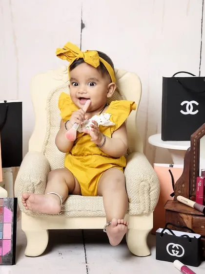 This little fashionista is sitting in her chair, surrounded by shopping bags and makeup, looking absolutely thrilled. A perfect theme for a future style icon.