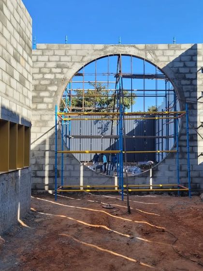 Another view of the gallery's construction, showing the scaffolding that supports the creation of the large, round window. This is the skeletal phase where architectural ideas become physical form.