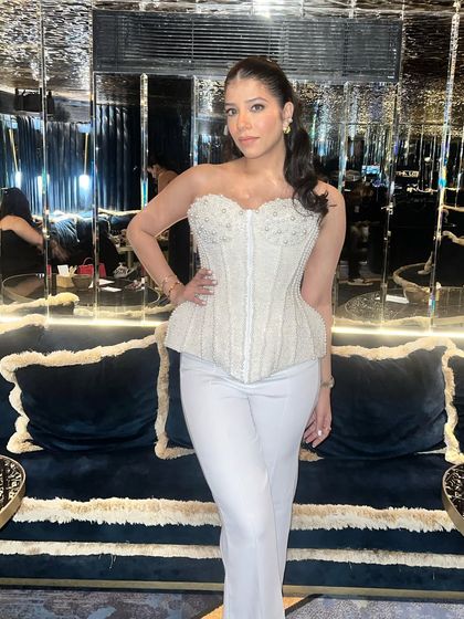 A confident and chic pose. The makeup is designed to look stunning in the low, ambient lighting of a fancy restaurant or bar.