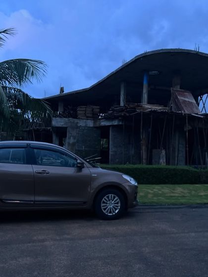A site visit to our 'Maritime Aboard' project in Visakhapatnam. The raw, unfinished structure with its dramatic curved roof stands as a powerful silhouette against the coastal sky.